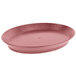 A red oval tray with a short base on a table.