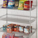 A Regency metal shelf with snacks in baskets.