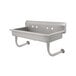 A stainless steel wall mounted Advance Tabco hand sink with 6 faucet holes.