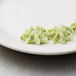 A white plate with three green pastries on it with an Ateco 8" polyurethane coated pastry bag.