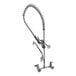 A chrome Equip by T&amp;S wall mounted pre-rinse faucet with a flexible hose.
