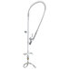 A T&S stainless steel deck mounted pre-rinse faucet with lever handles and a hose.