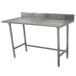 A stainless steel Advance Tabco work table with a backsplash.