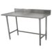 An Advance Tabco stainless steel work table with a backsplash and galvanized legs.
