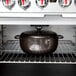 A Lodge Midnight Chrome enameled cast iron Dutch oven on a rack over a white background.