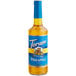 A close-up of a Torani Sugar-Free Pineapple Flavoring Syrup 750 mL glass bottle with a blue label.