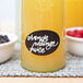 A glass of orange juice with a neon white tip on the rim.