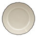 A white Homer Laughlin china bread and butter plate with a scalloped edge and black trim.