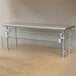 An Advance Tabco stainless steel table with glass sneeze guards.