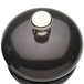 A black pepper mill with a silver knob.