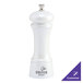 A white pepper mill with a silver top.