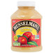 A plastic container of Musselman's Original Sweetened Applesauce on a table.