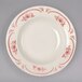 An ivory china bowl with a red rose design on the rim.