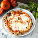 A Carlisle white melamine plate with a slice of pizza and tomato garnish on it.