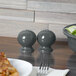 A wood table with a bowl of salad and a Fiesta Slate China pepper shaker.