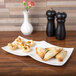 A white CAC China divided tasting plate with food on it.