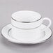 A white porcelain cup and saucer with silver stripes.