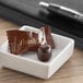 A chocolate buttermint candy in a white bowl.