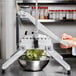 A person using a Global Solutions square lettuce cutter to cut lettuce into a metal bowl.