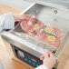 Vacuum sealing meat in a VacPak-It pouch on a counter.