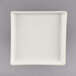 A white square china tray with a small rim.