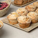 A rectangular porcelain platter with muffins and fruit.