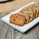 A 10 Strawberry Street Arctic Blue rectangular porcelain platter with cookies on a wood table.