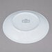A white 10 Strawberry Street porcelain saucer with a blue speckled design.
