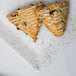 A blue speckled rectangular porcelain platter with two scones on it.