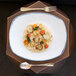 A rectangular porcelain platter with a plate of food and a fork.