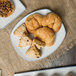 A rectangular porcelain platter with pastries on a table.