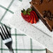 A piece of chocolate cake and strawberries on a 10 Strawberry Street blue speckled porcelain bread and butter plate.