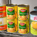 A group of Del Monte cans of Mandarin oranges on a shelf.