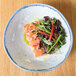 A 10 Strawberry Street Arctic Blue bowl filled with a vegetable salad on a table.