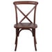 A Flash Furniture mahogany wooden stackable banquet chair with a cross back.