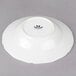 A white Tuxton china soup bowl with a scalloped edge.