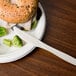 An 8" heavy weight cornstarch knife on a plate with a sandwich and broccoli.