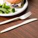 A heavy weight cornstarch knife and fork on a plate with broccoli.