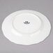 A white Tuxton china plate with black scalloped edges.