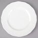 A Tuxton TuxTrendz Charleston white china plate with a scalloped edge.