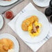 A Tuxton Charleston bright white china plate with breakfast food on a table.