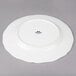 A Tuxton TuxTrendz Charleston white china plate with a scalloped edge and black rim.