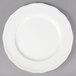 A Tuxton TuxTrendz Charleston white china plate with a scalloped edge.