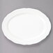 A Tuxton TuxTrendz white china oval platter with a scalloped edge.