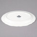 A bright white Tuxton oval platter with scalloped edges.