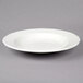 A Tuxton white china pasta bowl with a scalloped rim.