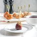 A Tuxton white china bread and butter plate with meatballs and red sauce on it.
