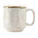 A white coffee mug with brown speckles.