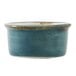 A blue ceramic Tuxton ramekin with brown specks on a table.