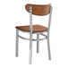 A Lancaster Table & Seating Boomerang chair with a wood seat and back and silver legs.